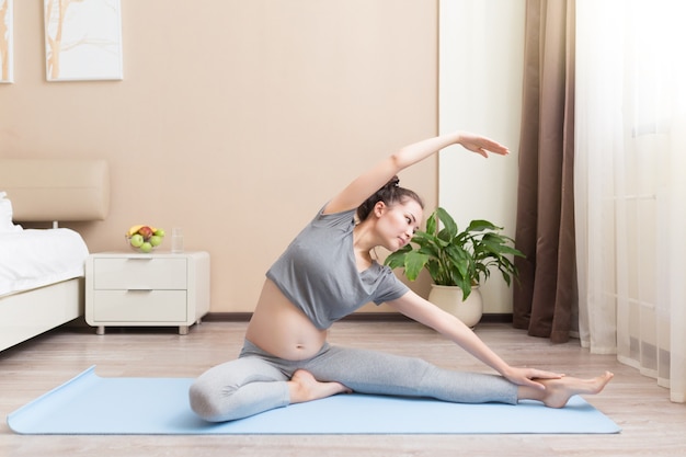 Jovem grávida no segundo trimestre fazendo exercício físico