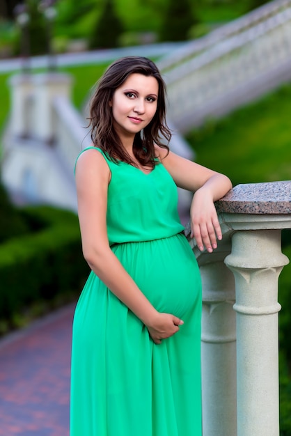 Jovem grávida posando com um vestido verde