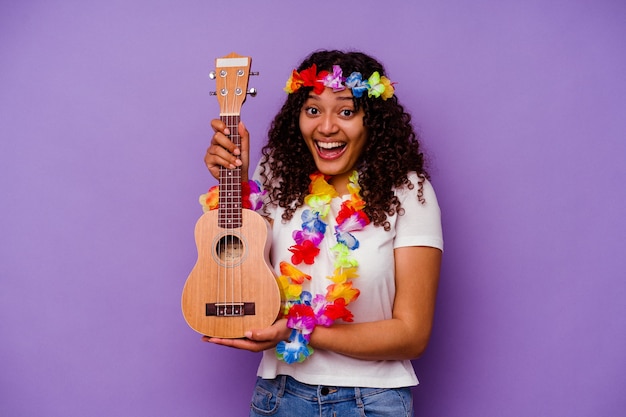 Jovem havaiana tocando cavaquinho isolada em fundo roxo