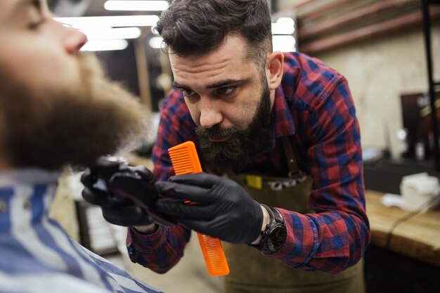 Foto jovem hippie bonito visitando a barbearia. corte e estilo de barba moderno e elegante.