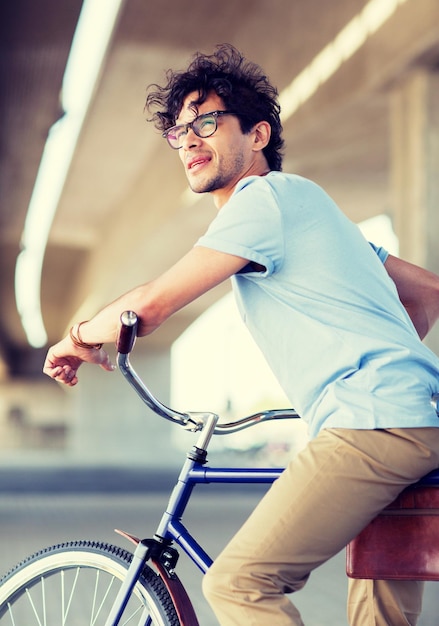 jovem hipster a andar de bicicleta de engrenagem fixa