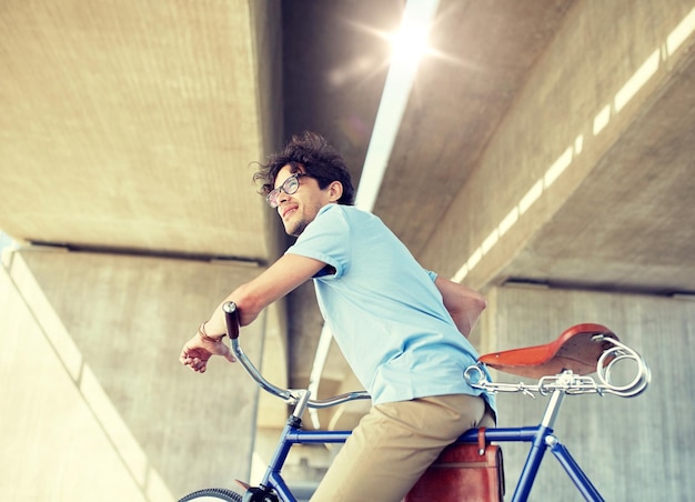 jovem hipster a andar de bicicleta de engrenagem fixa