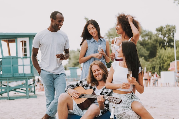 Jovem Hipster tocando guitarra beber champanhe