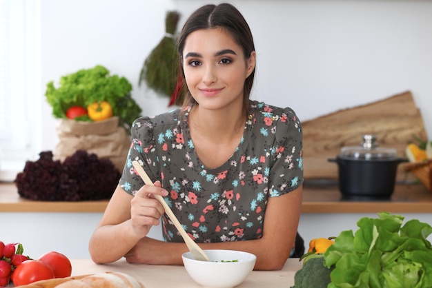 Jovem hispânica está cozinhando na cozinha