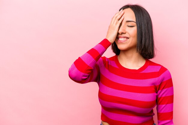 Jovem hispânica isolada em fundo rosa rindo feliz emoção natural despreocupada