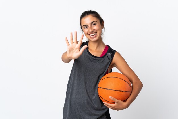 Jovem hispânica jogando basquete isolada, contando cinco com os dedos