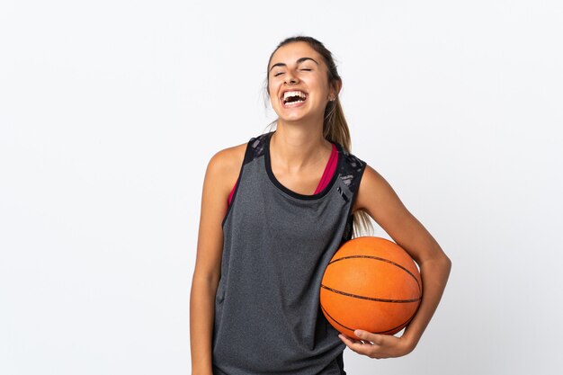 Jovem hispânica jogando basquete sobre um branco isolado rindo