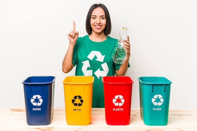 Jovem hispânica reciclando plástico isolado no fundo branco