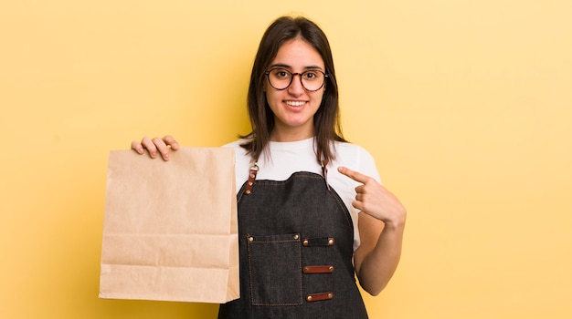 Jovem hispânica se sentindo feliz e apontando para si mesmo com um conceito animado de entrega de fast food