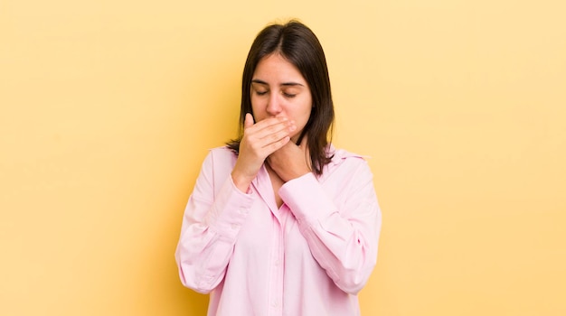 Foto jovem hispânica se sentindo mal com dor de garganta e sintomas de gripe tossindo com a boca coberta