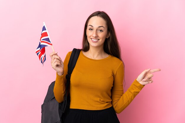 Jovem hispânica segurando uma bandeira do Reino Unido apontando o dedo para o lado