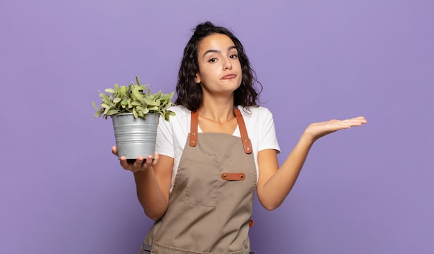 Jovem hispânica sentindo-se perplexa e confusa, duvidando, ponderando ou escolhendo opções diferentes com expressão engraçada