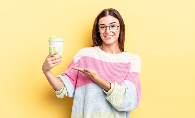 jovem hispânica sorrindo alegremente, sentindo-se feliz e mostrando um conceito. levar embora o conceito de café