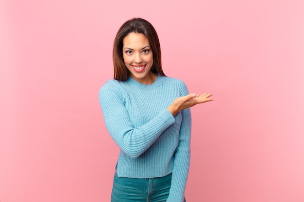 Jovem hispânica sorrindo alegremente, sentindo-se feliz e mostrando um conceito