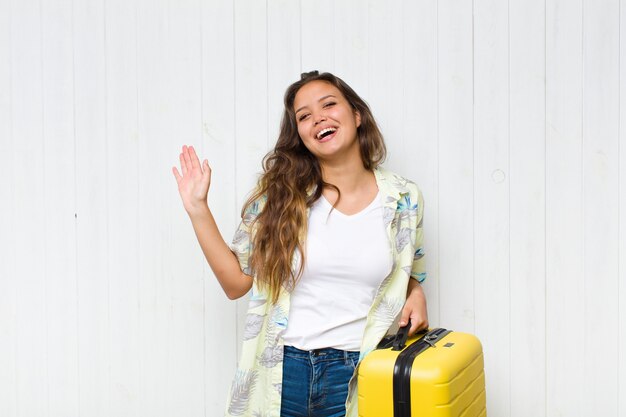 Jovem hispânica sorrindo e parecendo amigável, mostrando o número dois ou o segundo com a mão para a frente, em contagem regressiva