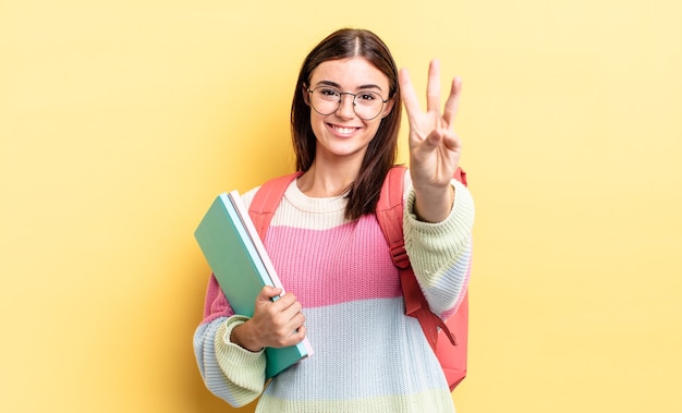 Jovem hispânica sorrindo e parecendo amigável, mostrando o número três. conceito de estudante