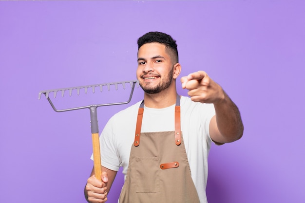 Jovem hispânico apontando ou mostrando. conceito de fazendeiro ou jardineiro