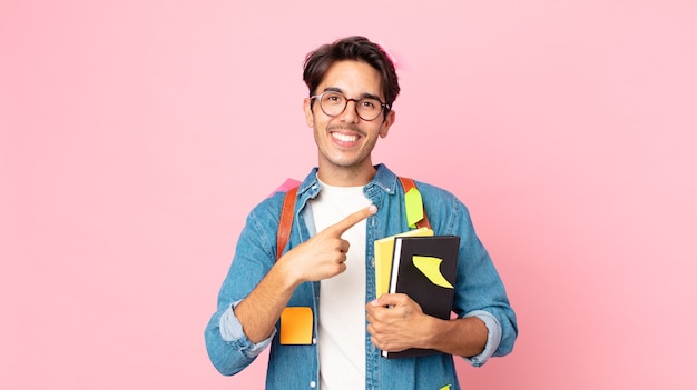 Jovem hispânico parecendo animado e surpreso, apontando para o lado. conceito de estudante