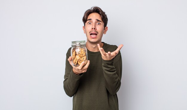 Jovem hispânico parecendo desesperado, frustrado e estressado. conceito de biscoitos