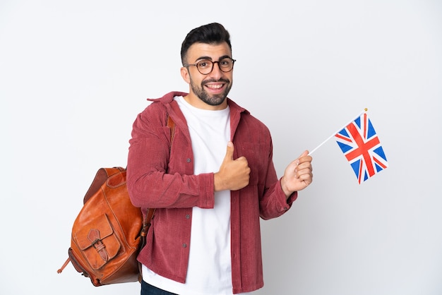 Jovem hispânico segurando uma bandeira do Reino Unido e fazendo um gesto de polegar para cima