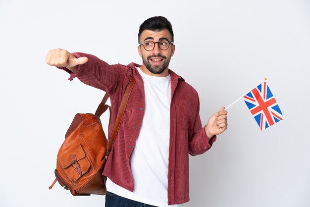 Jovem hispânico segurando uma bandeira do Reino Unido e fazendo um gesto de polegar para cima