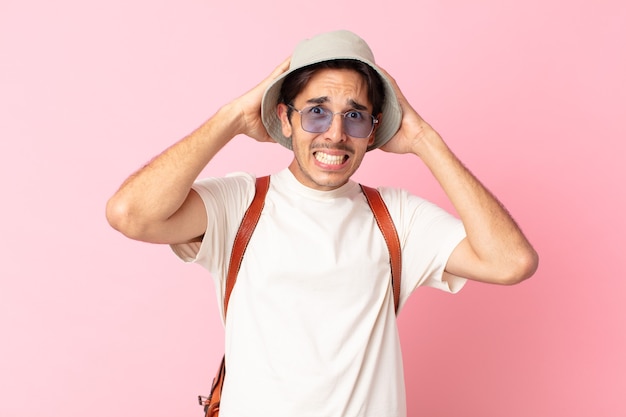 Jovem hispânico sentindo-se estressado, ansioso ou com medo, com as mãos na cabeça. conceito de verão