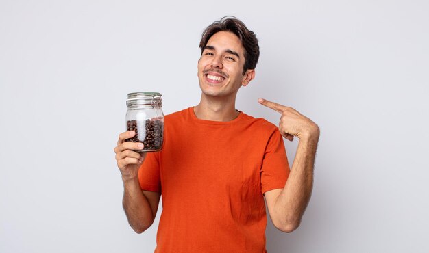 Jovem hispânico sorrindo com confiança apontando para o próprio conceito de grãos de café de sorriso largo