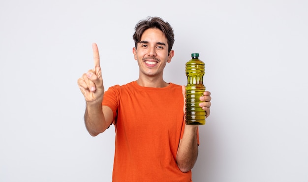 Jovem hispânico sorrindo e parecendo amigável, mostrando o número um. conceito de azeite