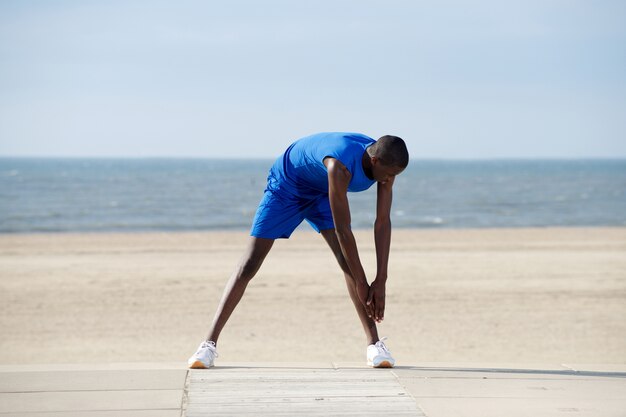 Jovem, homem americano africano, esticar, praia