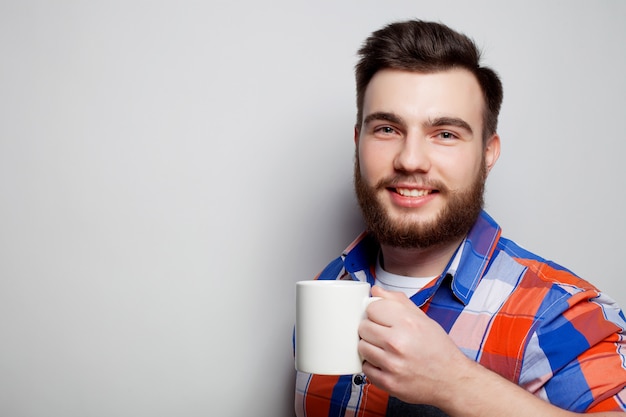 Jovem homem barbudo com uma xícara de café