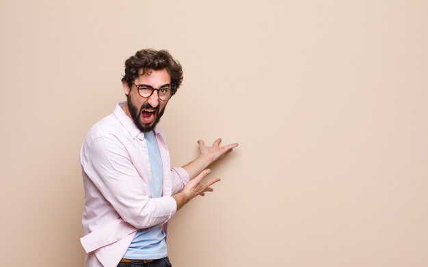 Jovem homem barbudo, expressando um conceito na parede