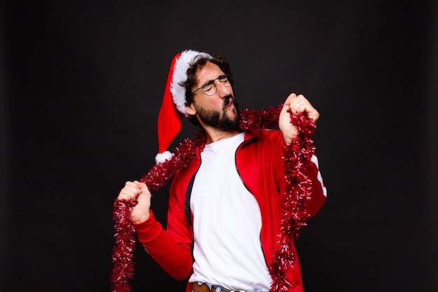 Jovem homem barbudo louco com chapéu de papai noel. conceito de natal