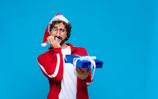 Jovem homem barbudo louco com chapéu de Papai Noel. Conceito de natal