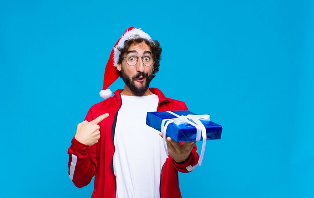 Jovem homem barbudo louco com chapéu de Papai Noel. Conceito de natal