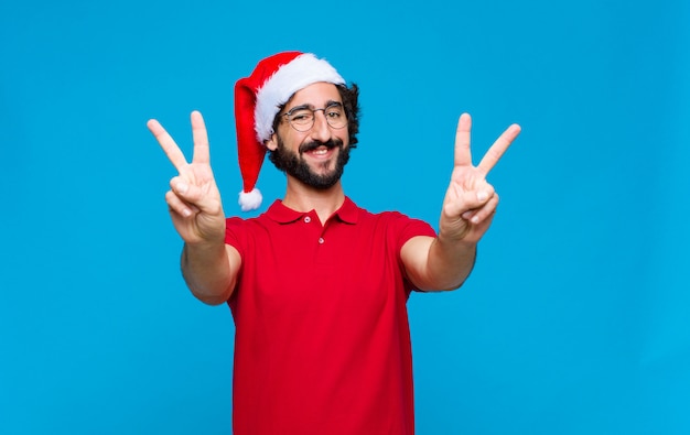 Jovem homem barbudo louco com chapéu de papai noel. conceito de natal