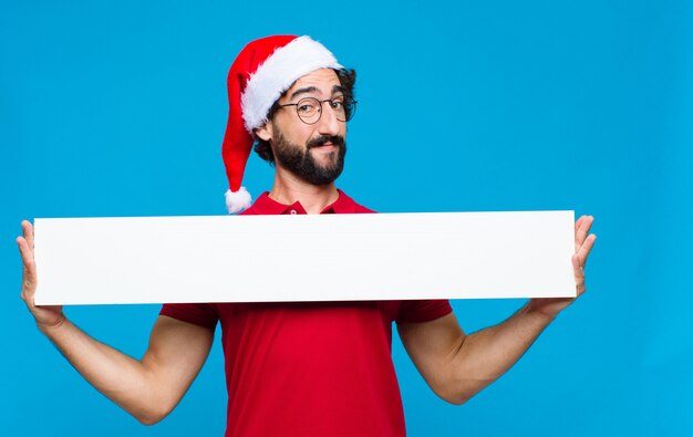 Jovem homem barbudo louco com chapéu de papai noel. conceito de natal