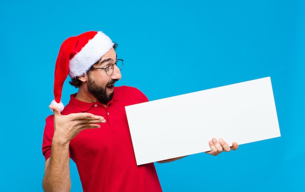 Jovem homem barbudo louco com chapéu de Papai Noel. Conceito de natal