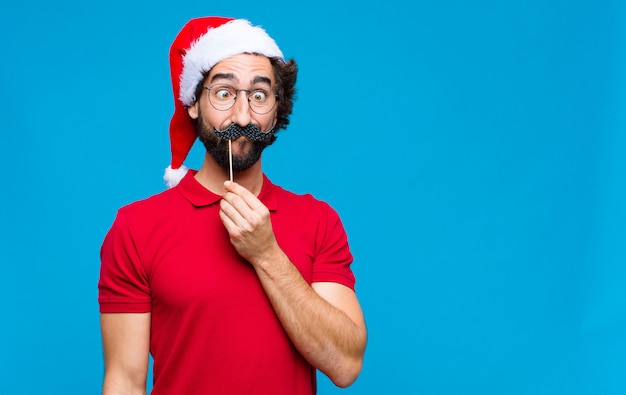 Jovem homem barbudo louco com chapéu de papai noel. conceito de natal