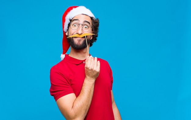 Jovem homem barbudo louco com chapéu de Papai Noel. Conceito de natal