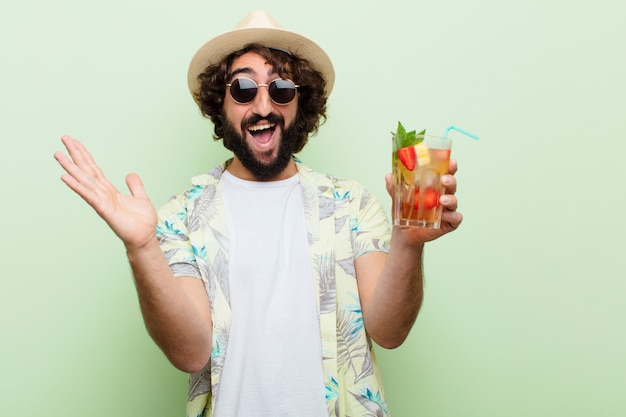 Jovem homem barbudo louco com um cocktail. turista