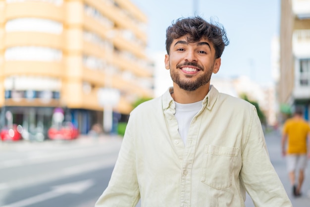 Jovem homem bonito árabe ao ar livre sorrindo