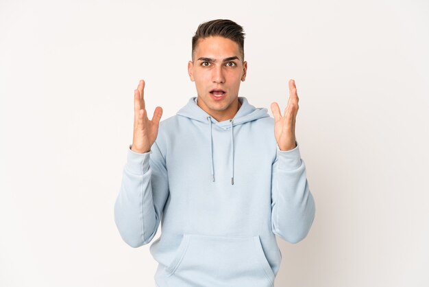 Jovem homem bonito caucasiano isolado comemorando uma vitória ou sucesso, ele está surpreso e chocado.