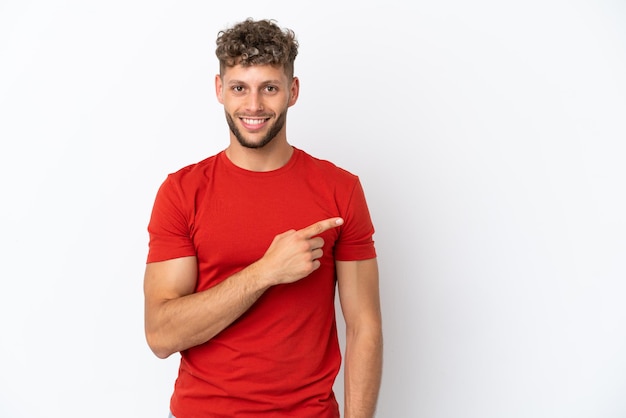 Jovem homem bonito, caucasiano, isolado no fundo branco, apontando para o lado para apresentar um produto