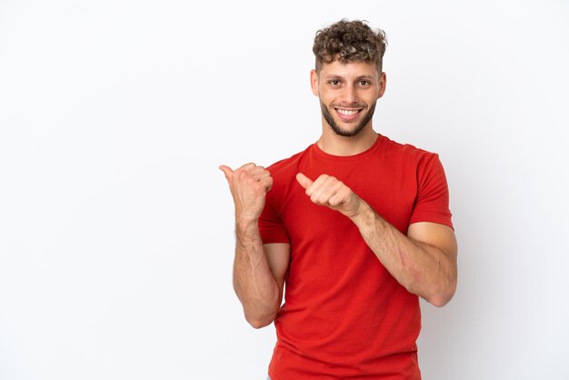 Jovem homem bonito, caucasiano, isolado no fundo branco, apontando para o lado para apresentar um produto