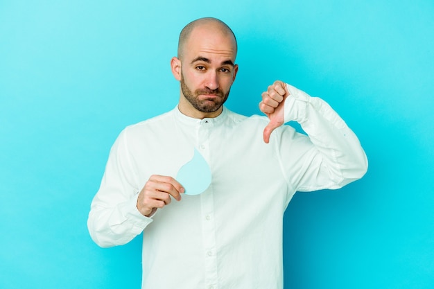 Jovem homem careca, caucasiano, comemorando o dia mundial da água, isolado em um fundo azul, mostrando um gesto de antipatia