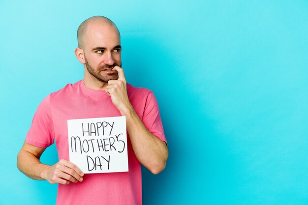 Jovem homem careca, caucasiano, segurando um cartaz do feliz dia das mães isolado