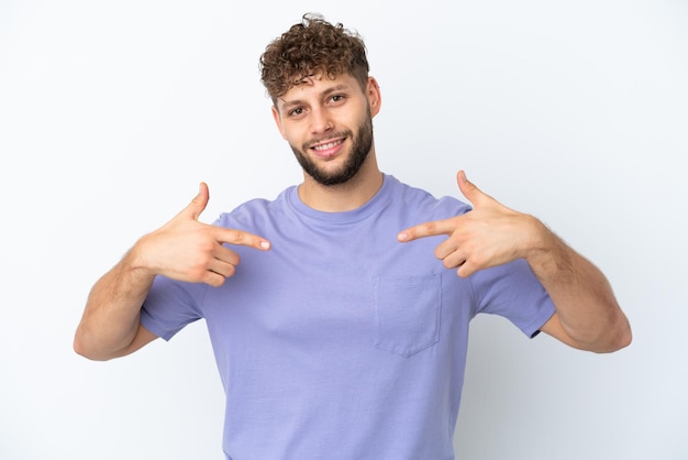 Jovem homem caucasiano bonito isolado no fundo branco orgulhoso e satisfeito