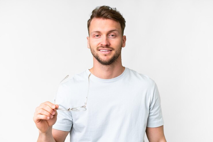Foto jovem homem caucasiano bonito sobre fundo branco isolado com óculos e expressão feliz
