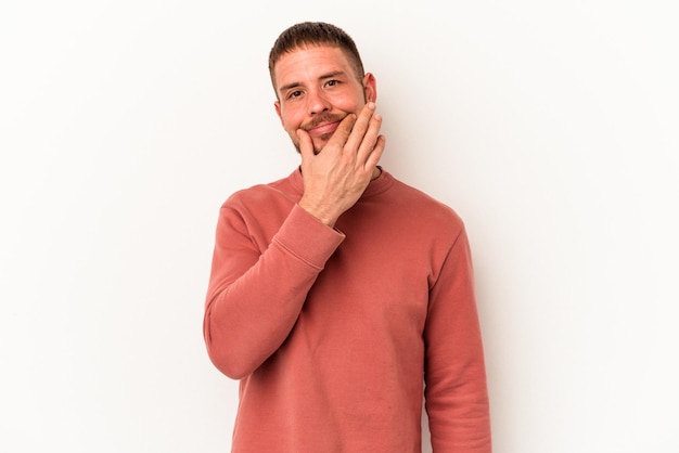 Jovem homem caucasiano com diastema isolado no fundo branco, duvidando entre duas opções.