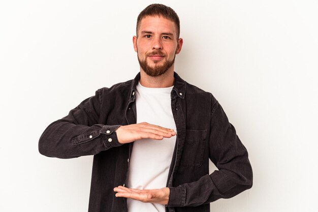 Foto jovem homem caucasiano com diastema isolado no fundo branco, segurando algo com as duas mãos, apresentação do produto.